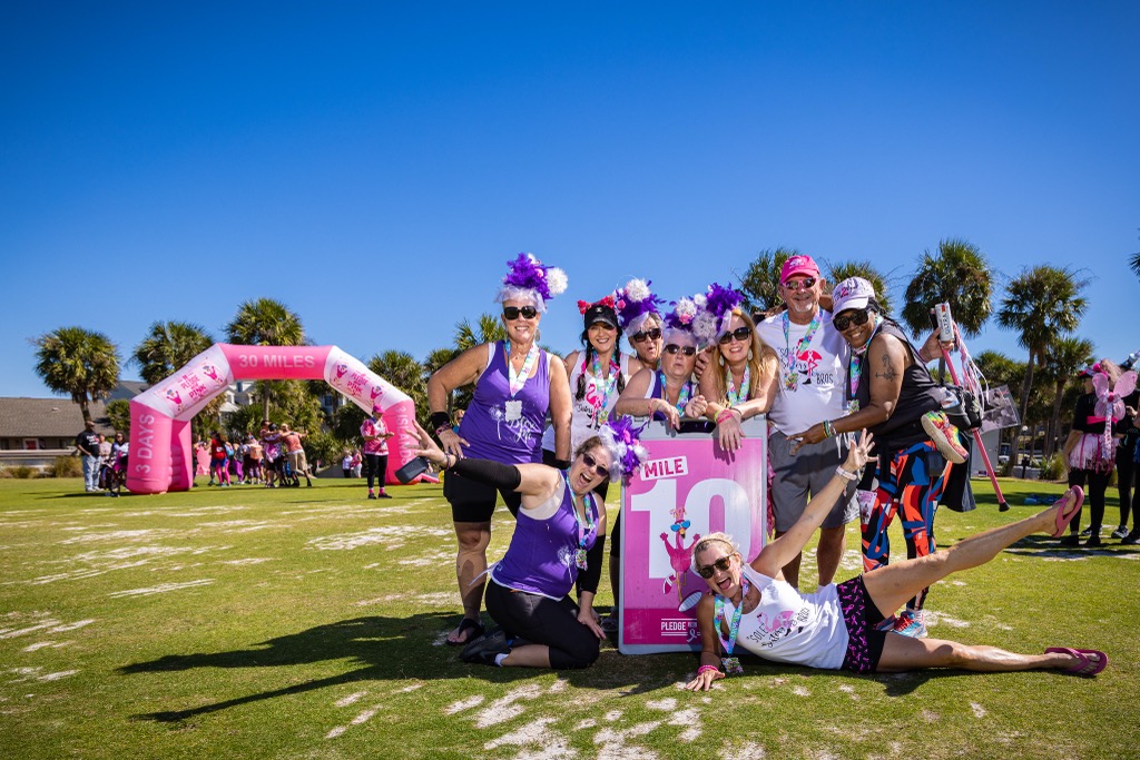 A team posing around the Mile 10 sign