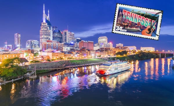The Nashville skyline lit up at night over the Cumberland River, with a riverboat and a "Greetings from Tennessee" postage stamp
