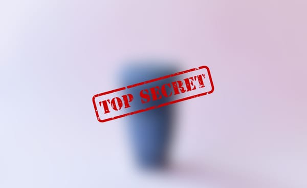 A blurred cup behind a red "Top Secret" stamp