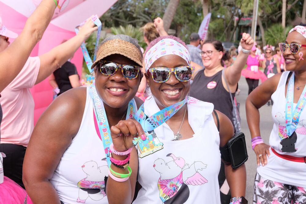 Two women proudly showing their Day 1 medals
