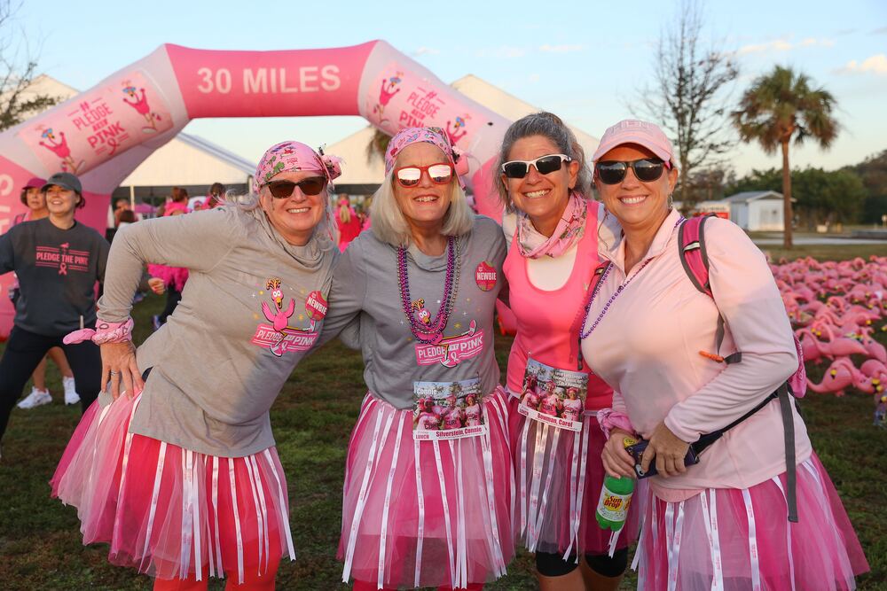 Group of four friends posing together at the finish line