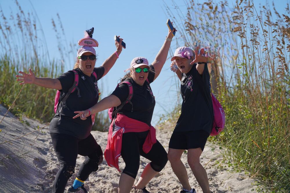 Three women posing playfully on the sand dunes