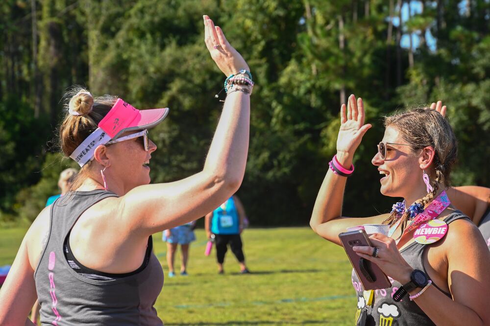 Two walkers high-fiving on a sunny field