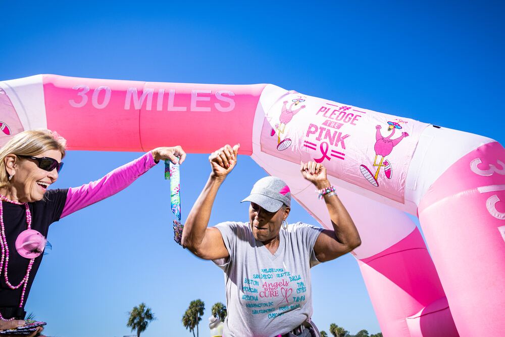Two walkers cheering as they cross under the 30 Miles arch