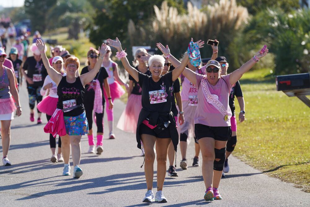 Walkers raising their arms as they come down the course