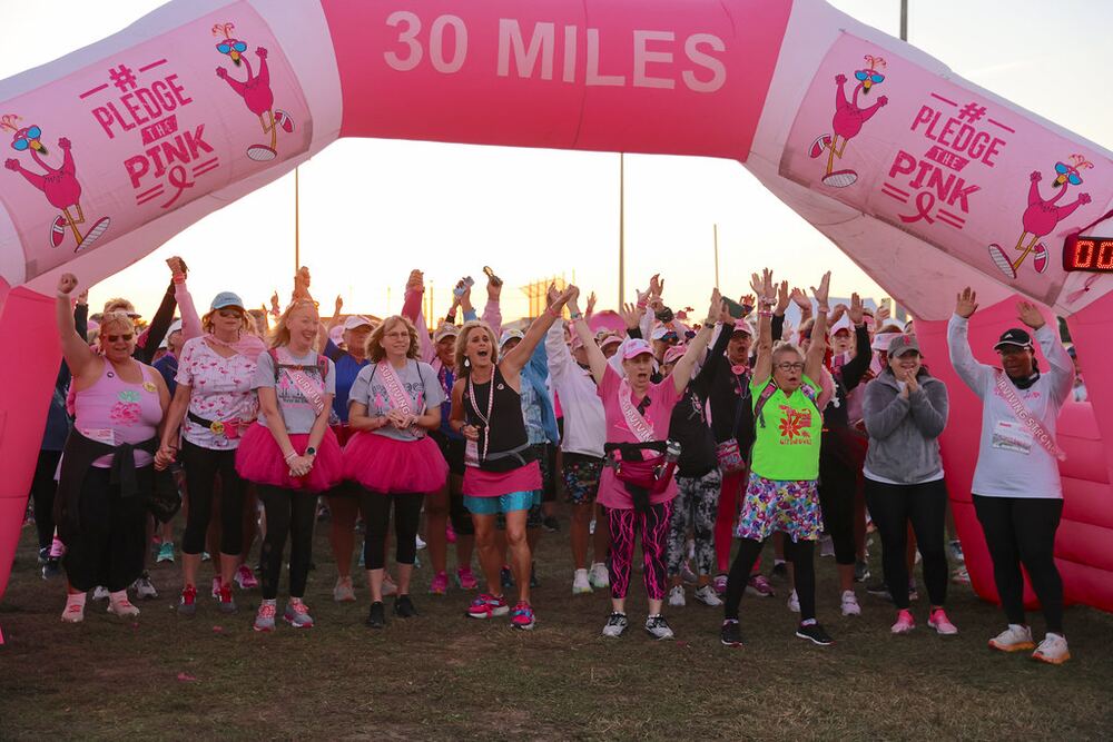 Crowd cheering with arms raised under the 30 Miles arch