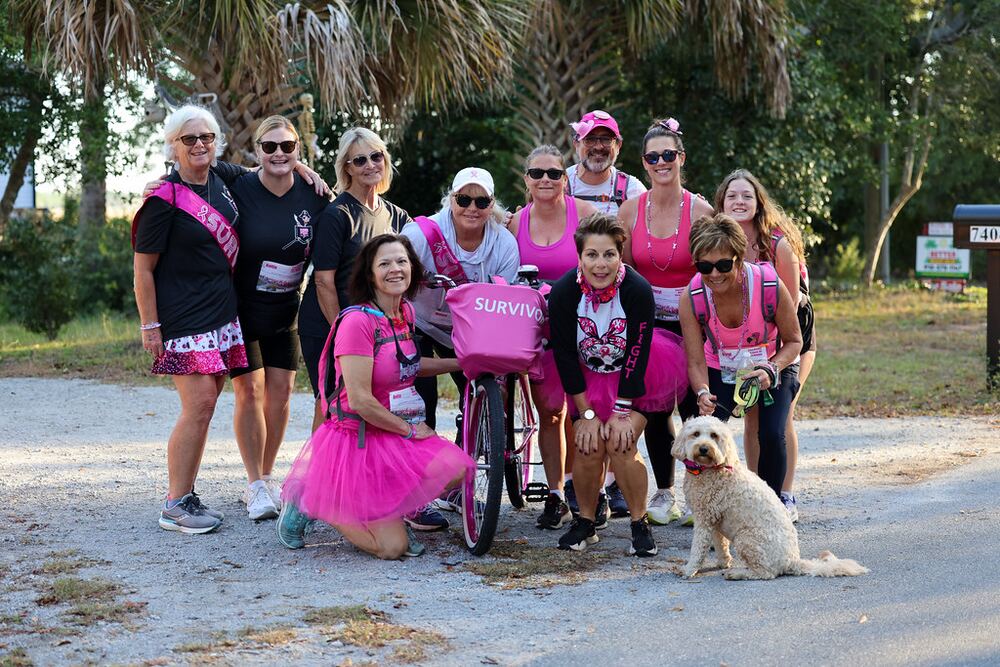 Team with a pink bike and a fluffy dog posing on a gravel road