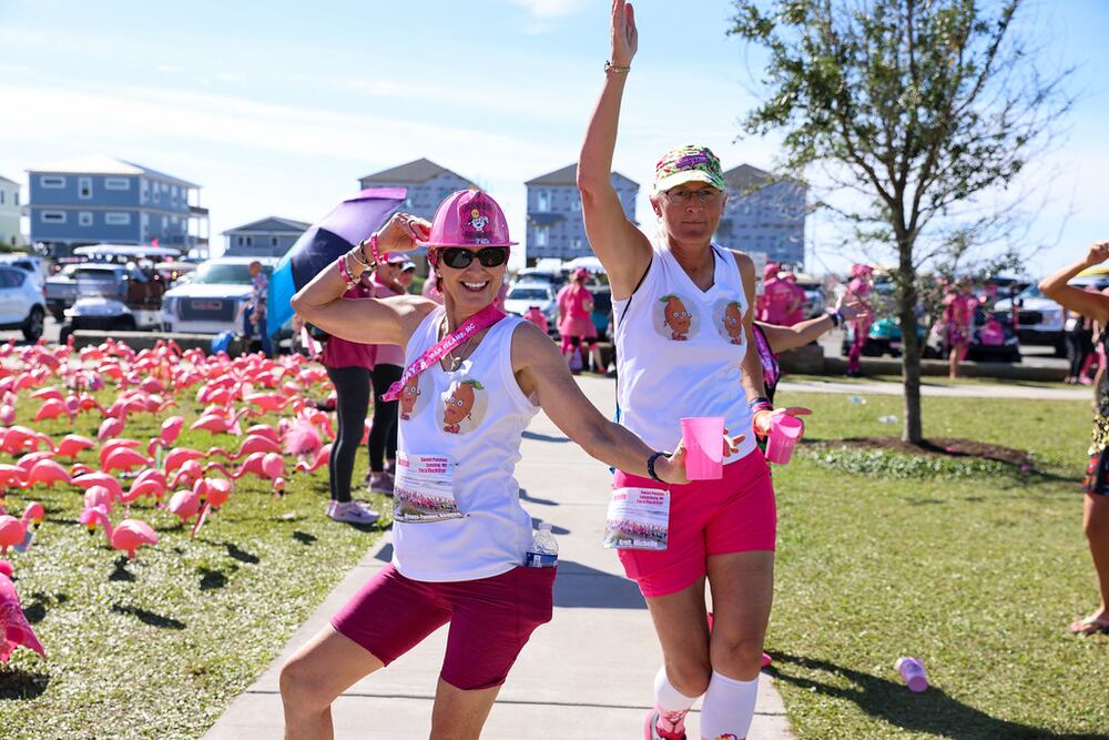 Two walkers posing among rows of pink flamingos