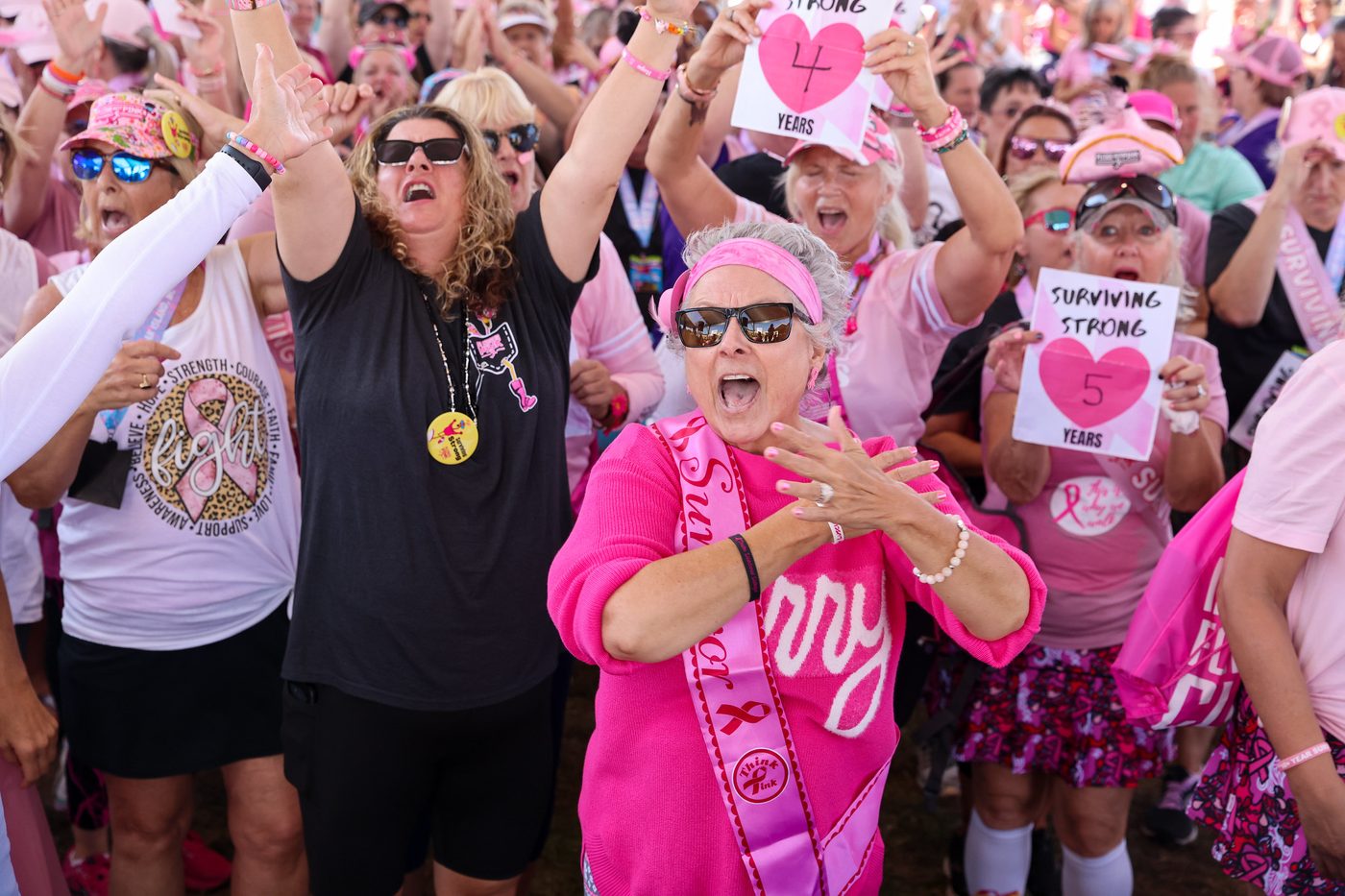 Pledge the Pink crowd cheering, survivor in pink sash front and center