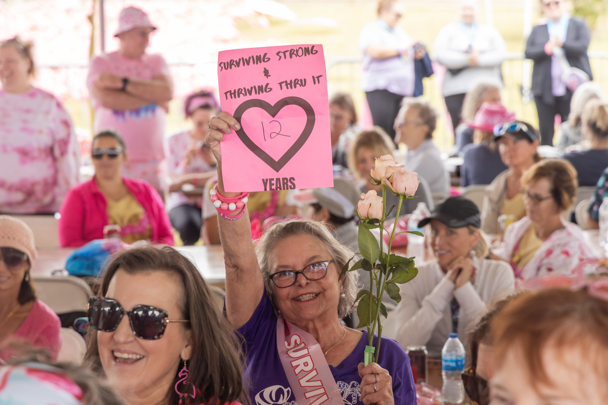 A survivor holding a hand-lettered 12 years sign at the luncheon