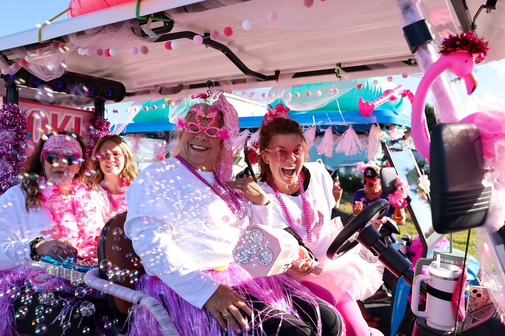 Costumed FlockStars laughing in a decorated golf cart as bubbles float around them