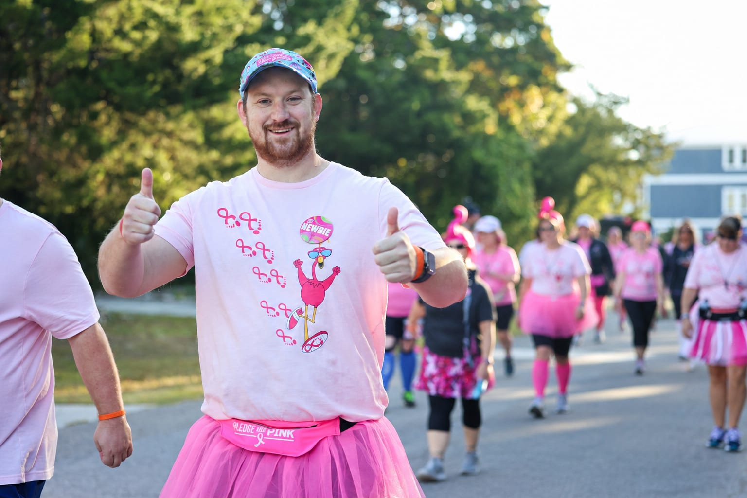 A first-year FlockStar in a pink tutu giving two thumbs up on the walk