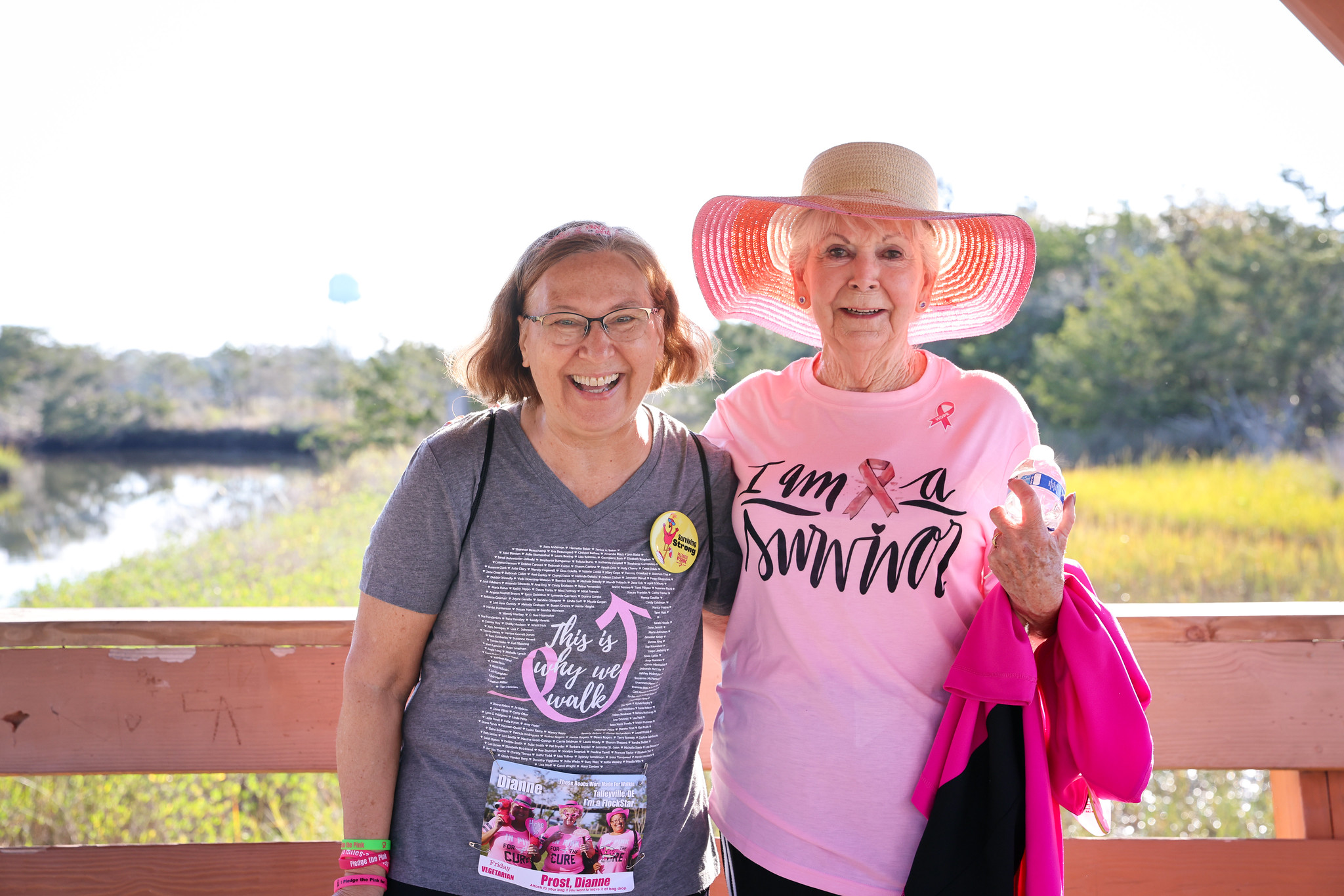 Two FlockStars on the marsh boardwalk, one in an I Am A Survivor shirt