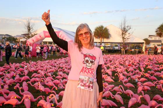 FlockStar giving a thumbs up among the flamingos